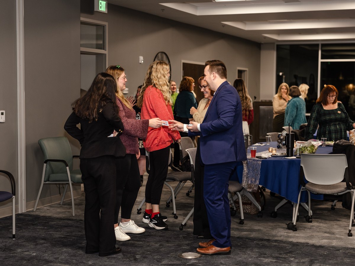 Tyler August performing close-up magic for a small group at a holiday party