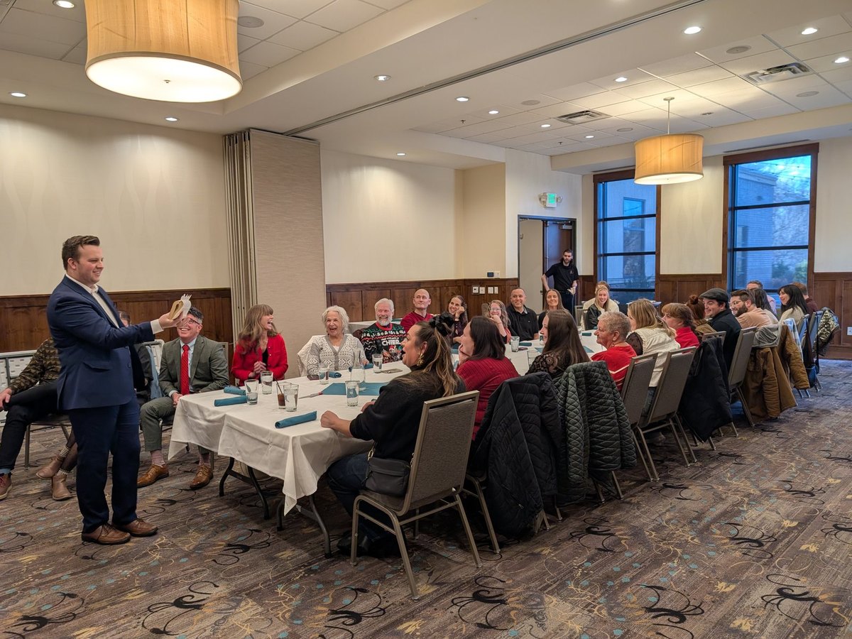 A room of guests watching Tyler August perform at a company holiday party