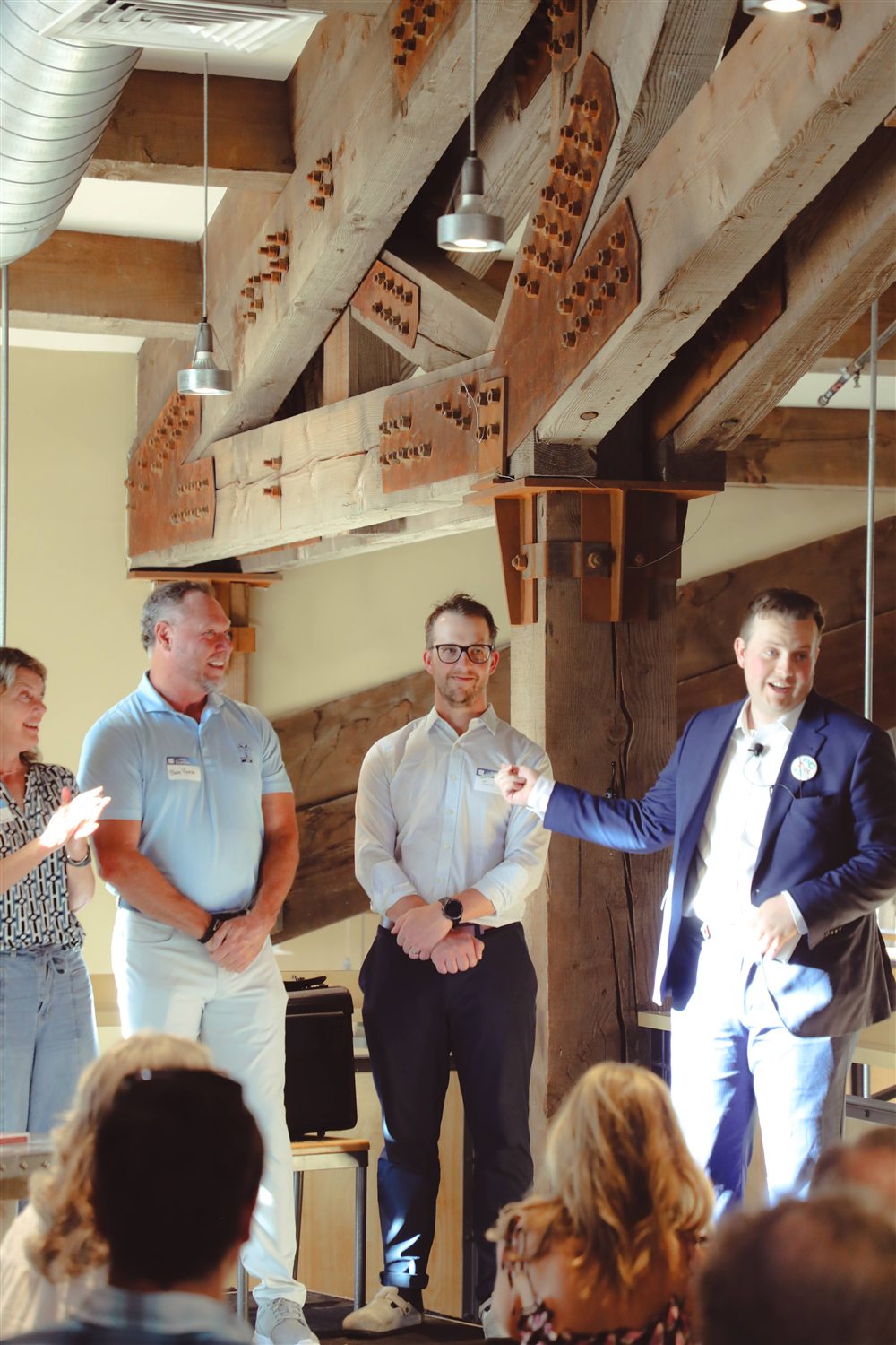 Tyler August performing on stage with volunteers at a Utah corporate event