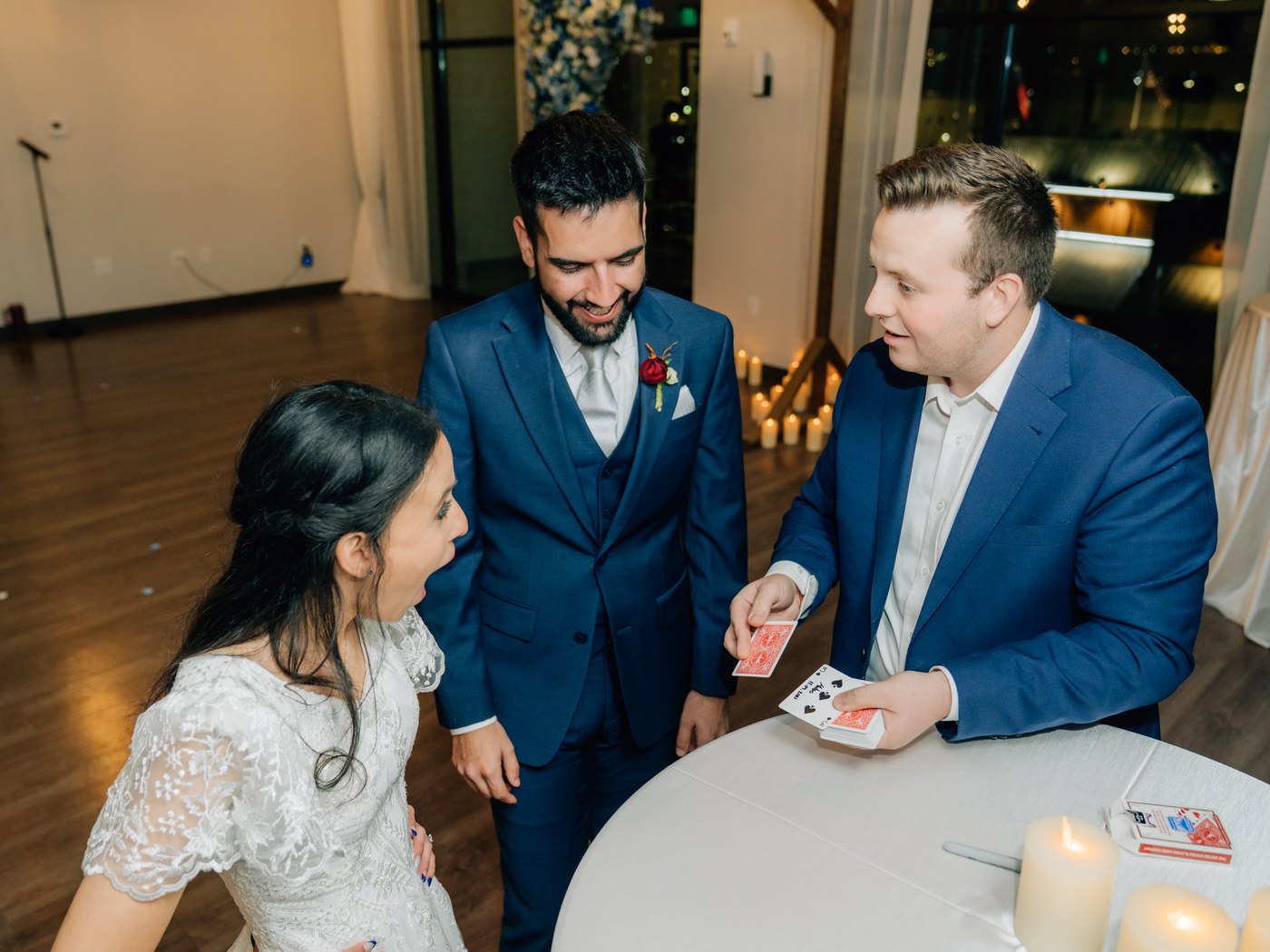 A bride and groom reacting to Tyler August's close-up card magic at their reception