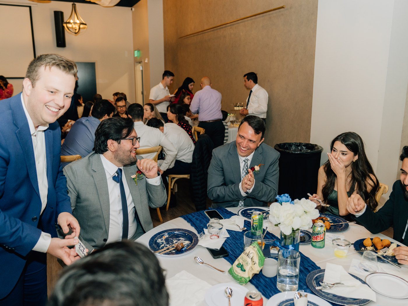 A table of wedding guests laughing and gasping together